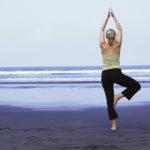 Woman in yoga pose on beach